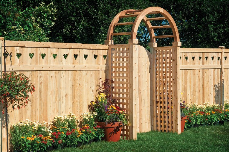 Eastern White Cedar one piece T&G Cedar privacy panels with Heart cutout shown with an arbor, square lattice side panesl and a style 20 gate